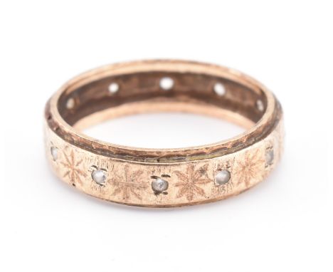 A hallmarked 9ct gold and white stone band ring. The yellow gold band ring having round cut white stones interspersed with et