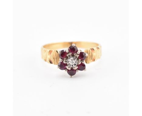 An 18ct gold ruby and diamond cluster ring. The 18ct yellow gold ring having a central illusion set round brilliant cut diamo