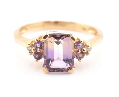 A hallmarked 9ct gold, ametrine, amethyst and diamond ring. The 9ct yellow gold ring having a central four claw set emerald c