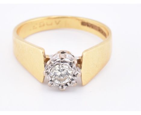 A hallmarked 18ct gold and diamond solitaire ring. The 18ct yellow gold ring set with a single illusion set round brilliant c