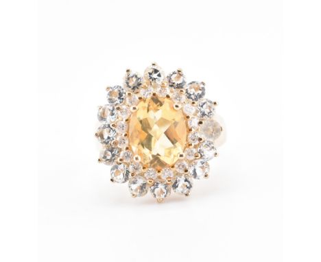 A hallmarked 9ct gold citrine, aquamarine and diamond cluster ring. The 9ct yellow gold ring set with a central oval cut citr