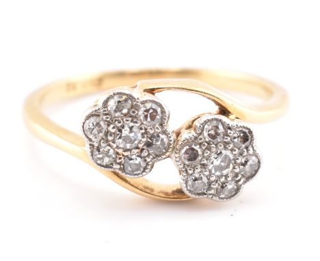 An 18ct gold and diamond crossover ring. The 18ct yellow gold ring having seven round brilliant cut diamonds set flower heads