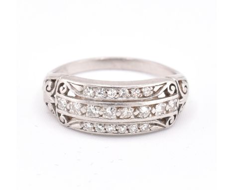 A 1920S platinum and diamond ring. The ring set with three rows of single cut diamonds with pierced and scrolled decoration t