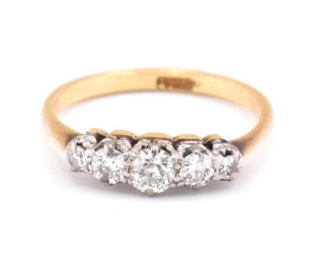 V An 18ct gold and diamond five stone ring. The 18ct yellow gold ring set with five claw set graduating round brilliant cut d