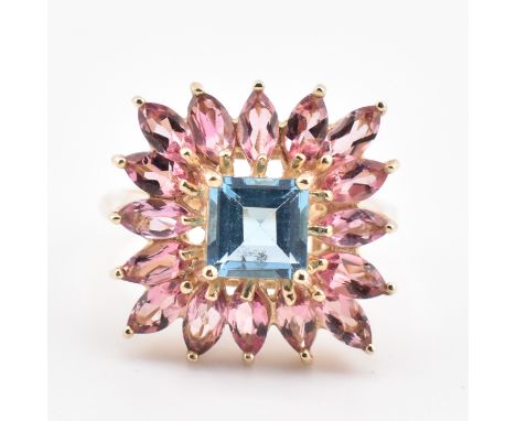 A hallmarked 9ct gold blue topaz and pink tourmaline cluster ring. The 9ct yellow gold ring having a central square cut sky b