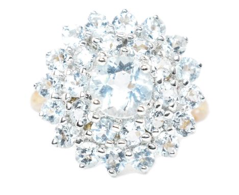 A hallmarked 9ct gold and aquamarine cluster ring. The ring set with a central four prong set round cut aquamarine surrounded