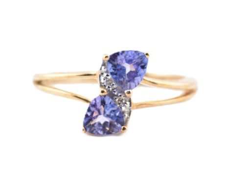 A hallmarked 9ct tanzanite and diamond crossover ring. The 9ct yellow gold ring set with two trilliant cut tanzanite and two 