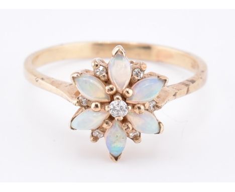 A 9ct gold opal and diamond cluster ring. The 9ct yellow gold ring set with a central round brilliant cut diamond surrounded 