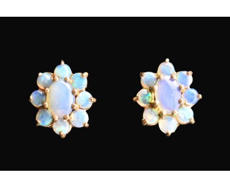 A pair of 9ct gold and opal cluster stud earrings. The 9ct yellow gold earrings having a central claw set oval opal cabochon 