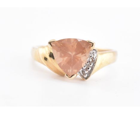 A hallmarked 9ct gold, Tibetan sunstone and topaz ring. The 9ct yellow gold ring set with a central trilliant cut Tibetan sun