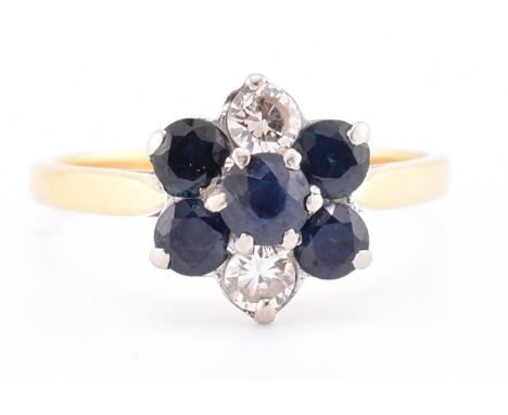 An 18ct gold sapphire and diamond cluster ring. The 18ct yellow gold ring having a flower-shaped head set with a central roun