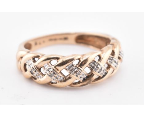 A hallmarked 9ct gold and diamond braided ring. The 9ct yellow gold ring having a braided design set with six round cut diamo