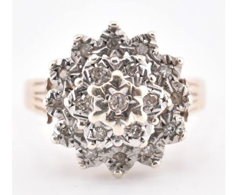 A hallmarked 9ct gold and diamond cluster ring. The 9ct yellow gold ring set with a cluster of nineteen illusion set round br