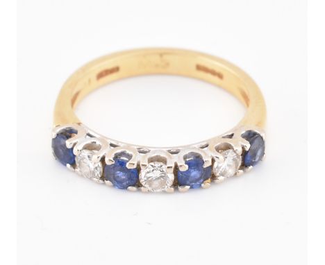 A hallmarked 18ct gold, sapphire and diamond half hoop ring. The 18ct yellow gold ring set with a single row of four round cu