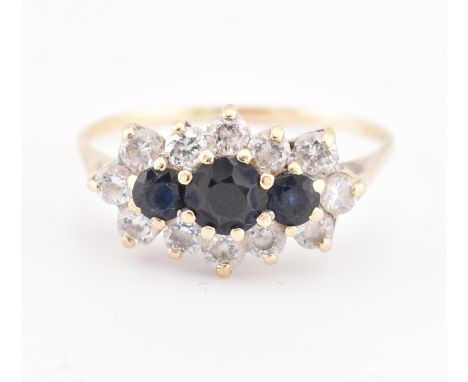 A hallmarked 18ct gold sapphire and white stone cluster ring. The 18ct yellow gold ring set with three graduating round cut s