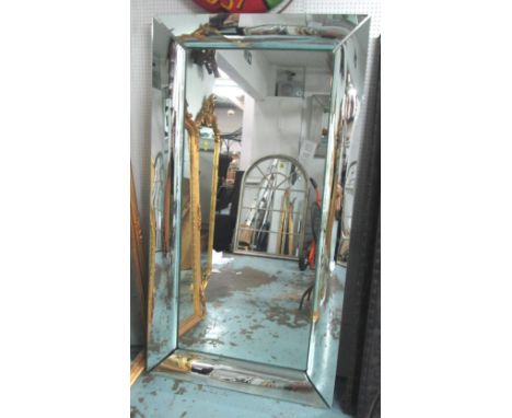 PHILIPPE STARCK WALL MIRROR, with curved polished metal frame, 106cm x 196cm H. with a small circular hole in plate for the i