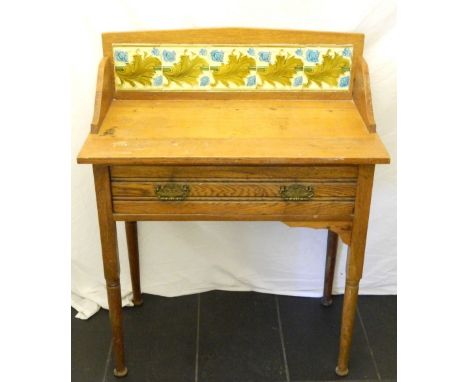 EDWARDIAN LIGHT OAK WASH STAND
the raised tilled back with shaped side supports above a frieze drawer, standing on turned tap