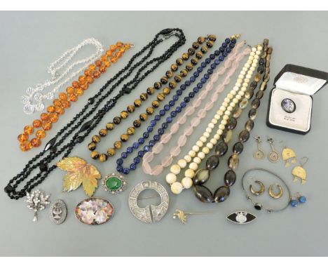 A collection of costume jewellery, including a graduated ivory bead necklace, an amber bead necklace, and a silver penannular