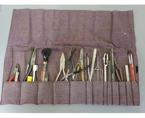 A roll of jeweller's tools, including pliers, brush, and files, etc