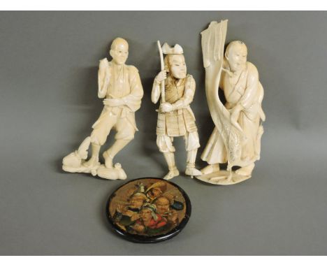 Three Japanese carved ivory figures, and a papier mâché snuff box lid