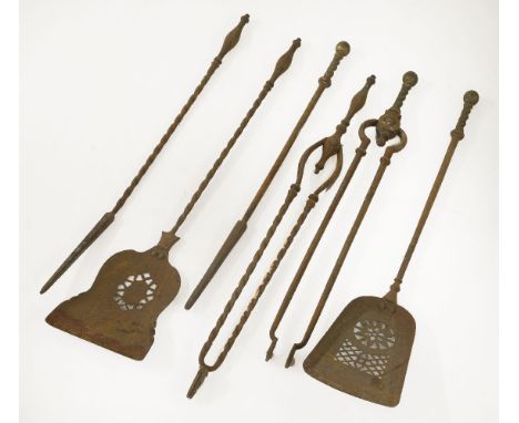 Two sets of three iron fire tools, one with brass handles