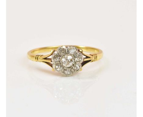 An 18ct yellow gold and diamond seven stone flower head ring, size N, approx 2.06g.