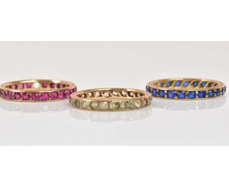 Three yellow metal dress eternity rings, sizes K, combined approx 5.32g (3).Condition Report: The pink stone ring is missing 