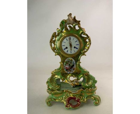 A late 19th century French green porcelain floral decorated eight day mantel clock, in elaborate gilt heightened Rococo frame