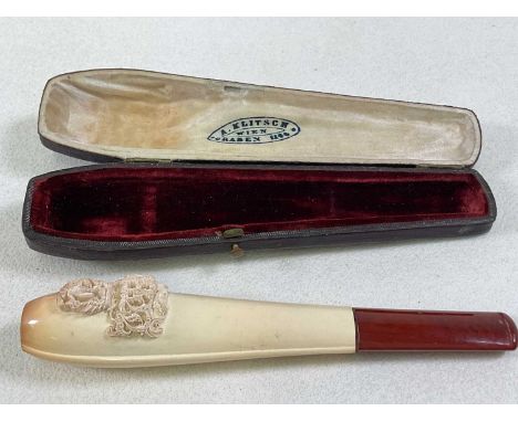 A leather cased velvet lined carved Meerschaum pipe, decorated with a nude figure above scrolling initials and with amber mou
