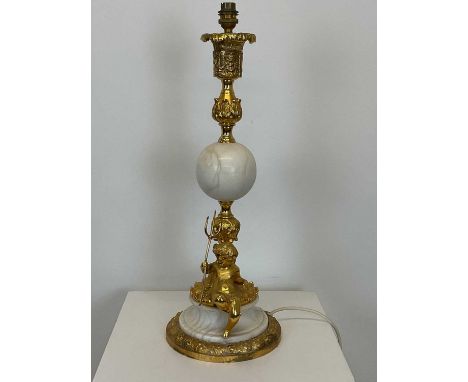 A decorative Continental gilt over metal table lamp with a white marble ball to the centre and circular base and a reclined c
