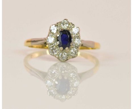 An 18ct yellow gold sapphire and diamond oval cluster ring with central sapphire within a border of eight diamonds, the ring 