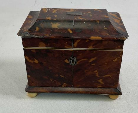 X A Regency tortoiseshell tea caddy, with two interior divisions and raised on turned ivory feet, 15 x 17 x 11cm (af).IVORY E