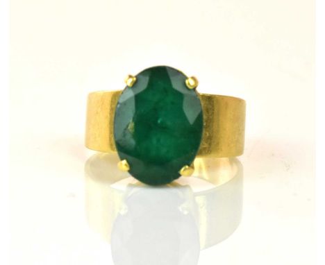 An 18ct yellow gold and Colombian emerald ring, the oval cut stone weighing approx 8ct with four claw setting, size U 1/2, ap