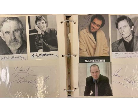 A black ring binder containing black and white and colour photo images, signed by actors and TV celebrities including Rowan A