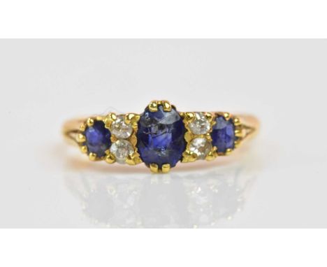An 18ct yellow gold sapphire and diamond ring set with three graduated sapphires and four small diamonds, size K 1/2, approx 