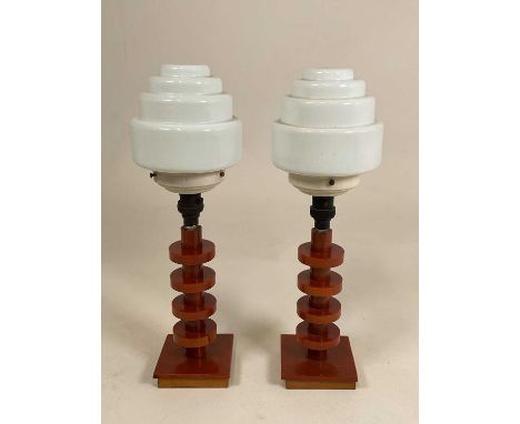 A pair of amber bakelite Art Deco lamps with stepped opaque glass shades, height 44cm (2).Provenance: They are rather rudimen