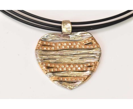An articulated 18ct white and yellow gold diamond set heart shaped pendant on triple leather collar with 18ct white gold clas