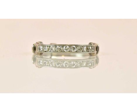 A white metal diamond half eternity ring set with nine round brilliant cut diamonds and with unusual pierced detail to the sh
