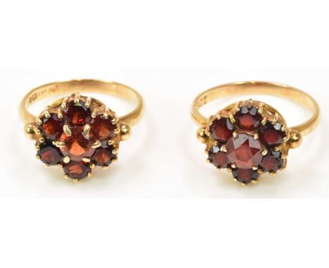 A pair of 9ct yellow gold garnet set flower head rings, sizes K and L 1/2, combined approx 5.82g (2).