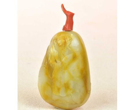 A Chinese carved jade snuff bottle, with russet inclusions and with coral stopper, length 84mm.Condition Report: No visible s
