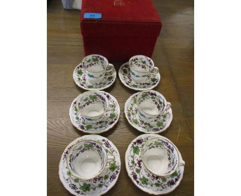 A set of six Royal Crown Derby coffee cans and saucers having a white background with grapevine decoration 
