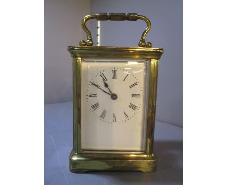 An early 20th century brass carriage clock having white enamelled dial with Roman numerals, 4 1/4" excluding handle 