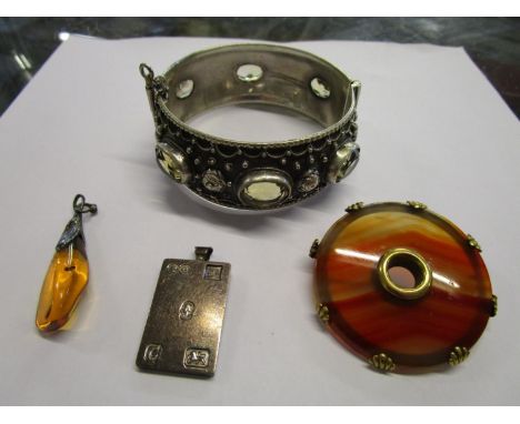 A Victorian Scottish agate brooch in a yellow metal shelling, a silver ingot pendant, silver set and amber pendant and a 800 