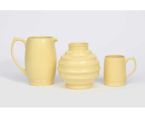 A Wedgwood Pottery vase designed by Keith Murray, ribbed ovoid form with collar rim, covered in a yellow Matt Straw glaze, an