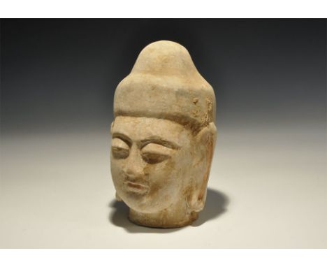 . An undated archaistic ceramic head of Buddha with black pigment to the hair and brows, red to the lips, coral-pink to the e