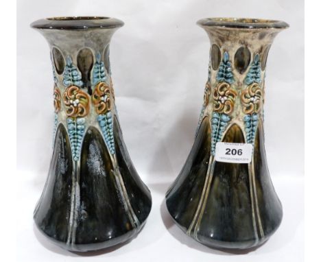 A pair of Arts and Crafts ceramic vases moulded with foliage on a mottled green glaze. 10' high. One vase with repair to rim