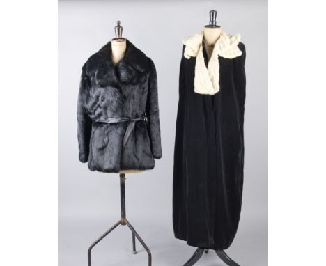 A 1940s musquash fur jacket; together with a 1970s dyed black coney jacket; and a 1930s black velvet evening cloak trimmed wi