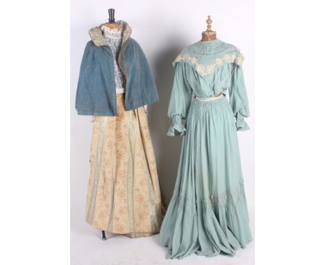 An early 20th century blue woollen two-piece costume; a 19th century floral silk and eau de Nil velvet striped skirt, a white