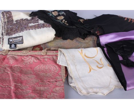 A late 19th century black embroidered apron, a cream fringed shawl, an early 20th century petticoat, a woolwork panel, a pink