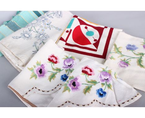 A quantity of assorted textiles, including: embroidery designs, velvet, table cloths, a pink and blue eiderdown and miscellan